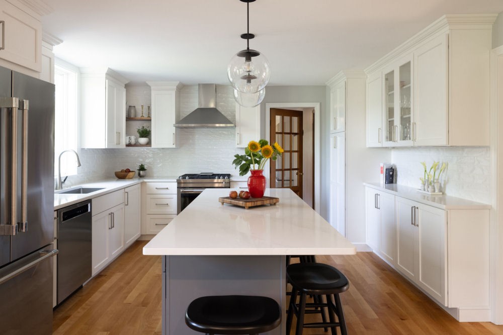 Kitchen Design in Wakefield MA with white kitchen cabinets and a gray island.