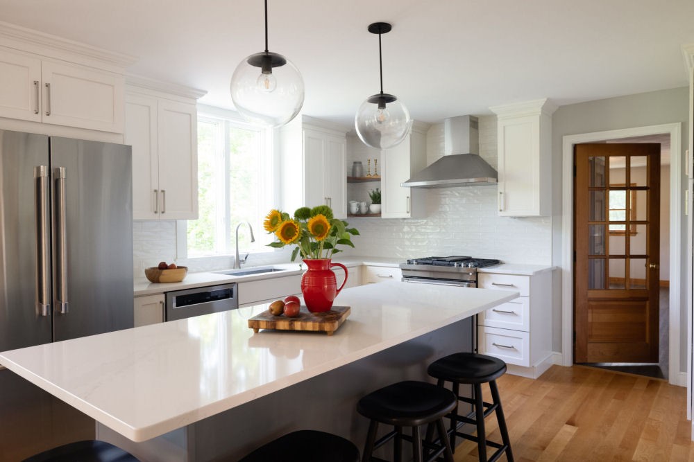 Kitchen Design in Wakefield MA with white kitchen cabinets and a gray island.