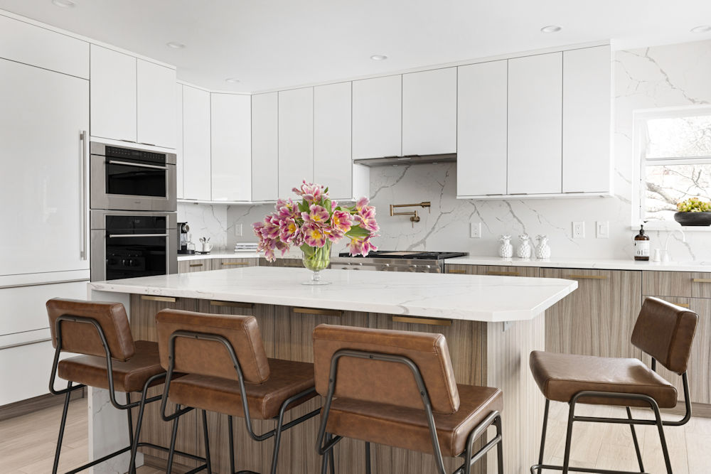 Contemporary kitchen in Lynnfield MA with high gloss white upper cabinets, wood grain lower cabinets, and brown leather counter stools.