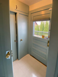 Before photo of a mudroom with sliding doors, painted light blue