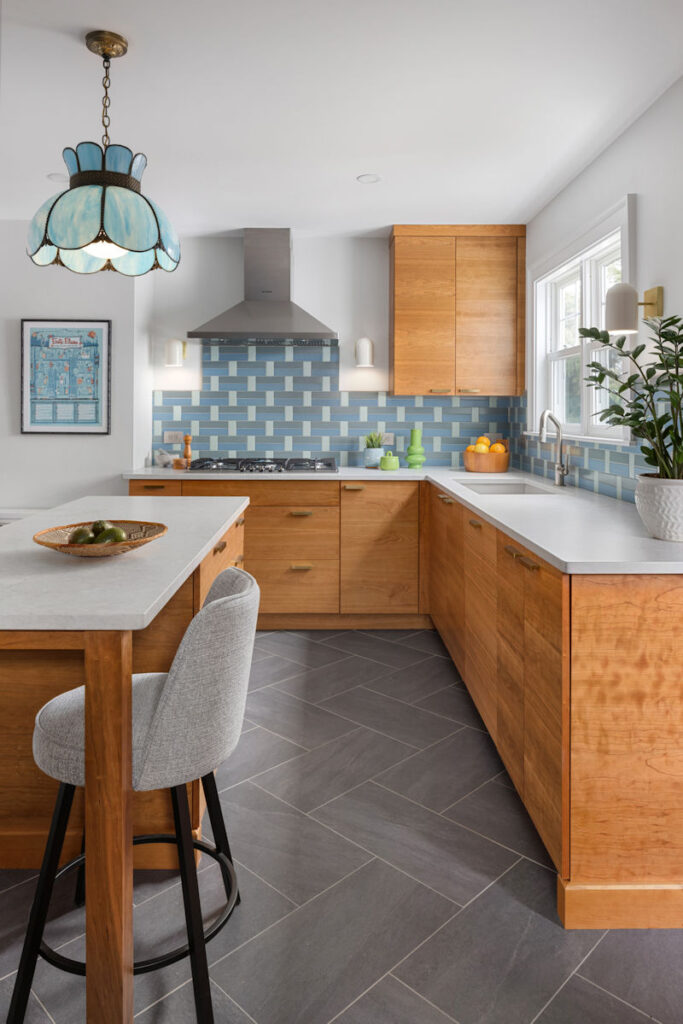 Medford Vintage Kitchen Design and Remodel with cherry cabinets, a center island, herringbone tile floor, and a custom tile backsplash in shades of blue.
