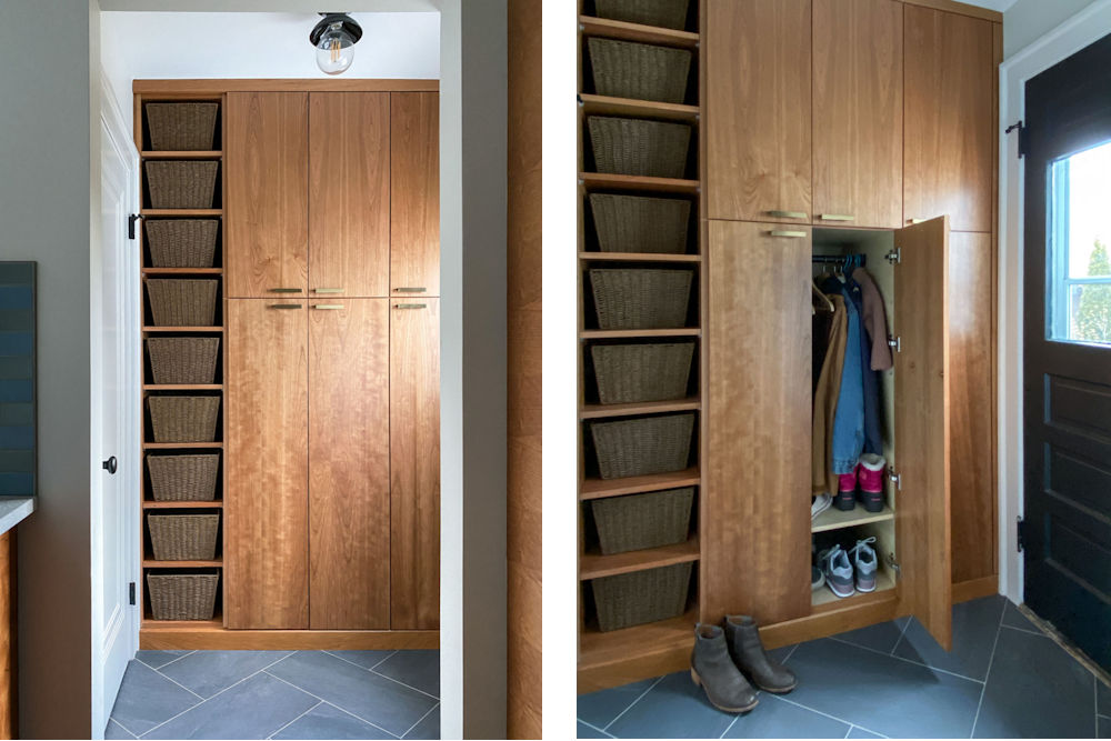 New mudroom remodel with cherry cabinetry, a tall bank of open shelves with baskets, and a closet for jackets, bags, and shoes,