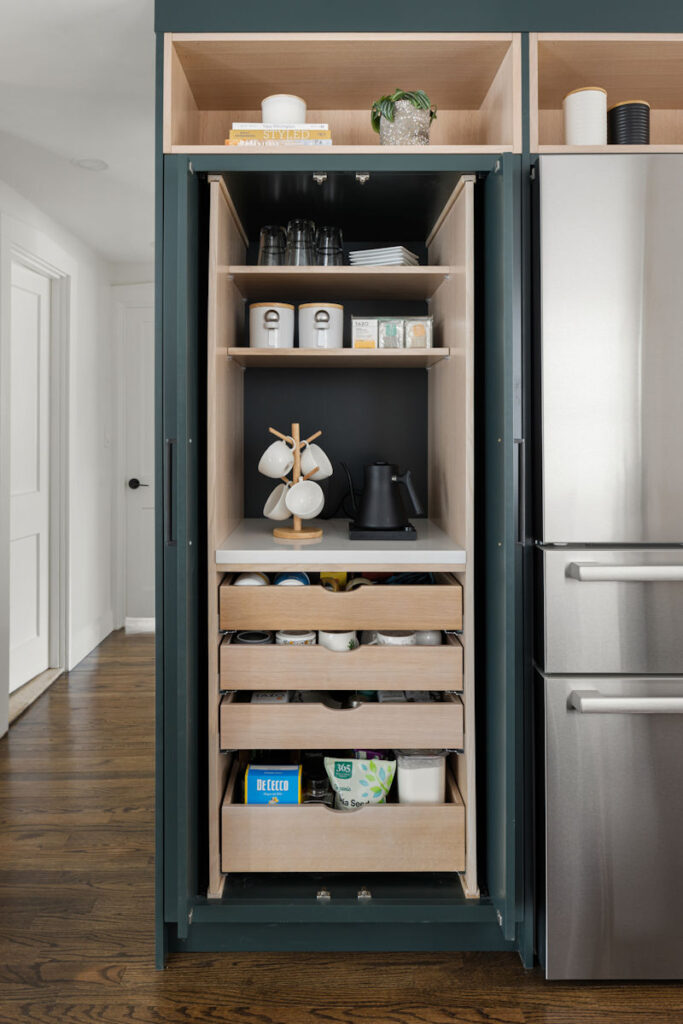 Modern Cape Kitchen beverage center pantry cabinet, with rift-sawn white oak and hunter green cabinetry and pullout drawers.