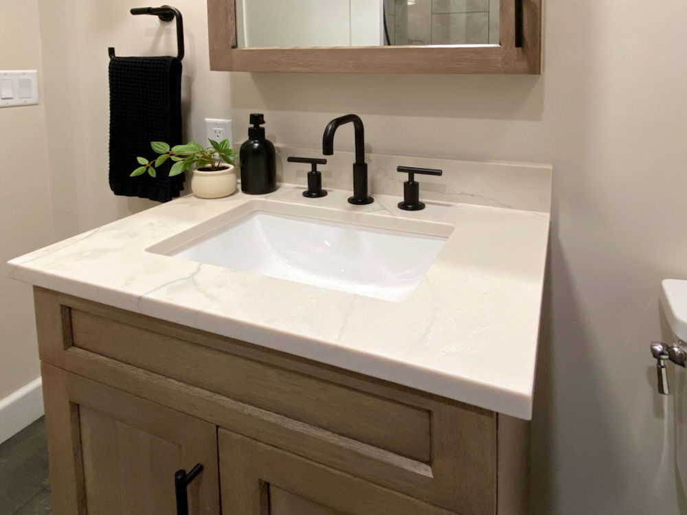Stoneham home remodeling project bathroom design and remodel with white oak vanity and medicine cabinet, quartz countertop, and matte black fixtures