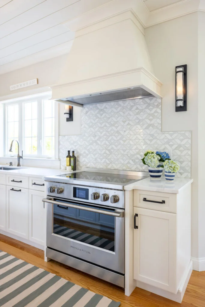 North Reading kitchen remodel with white cabinetry and a Fisher & Paykel induction range - McGuire + Co. Kitchen & Bath