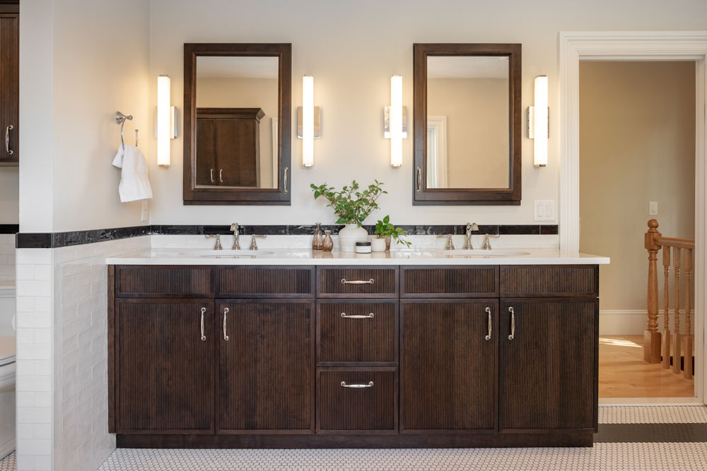 Bathroom remodel with dark stained reeded vanity cabinetry with double sinks and quartz countertop - McGuire + Co. Kitchen & Bath