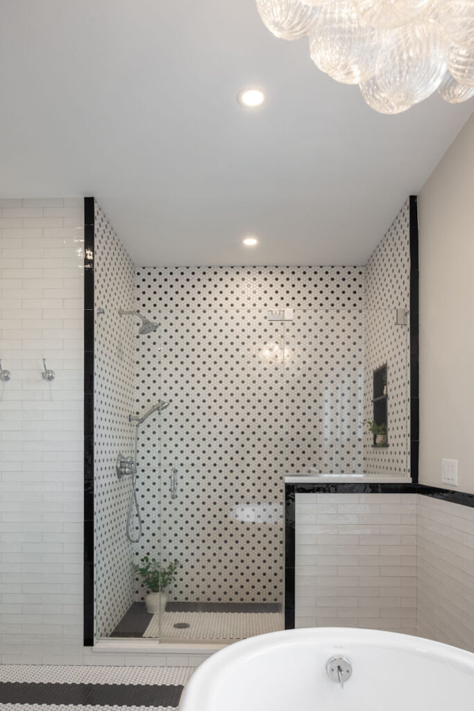 Bathroom remodel with custom black and white mosaic tile shower and soaking tub - McGuire + Co. Kitchen & Bath