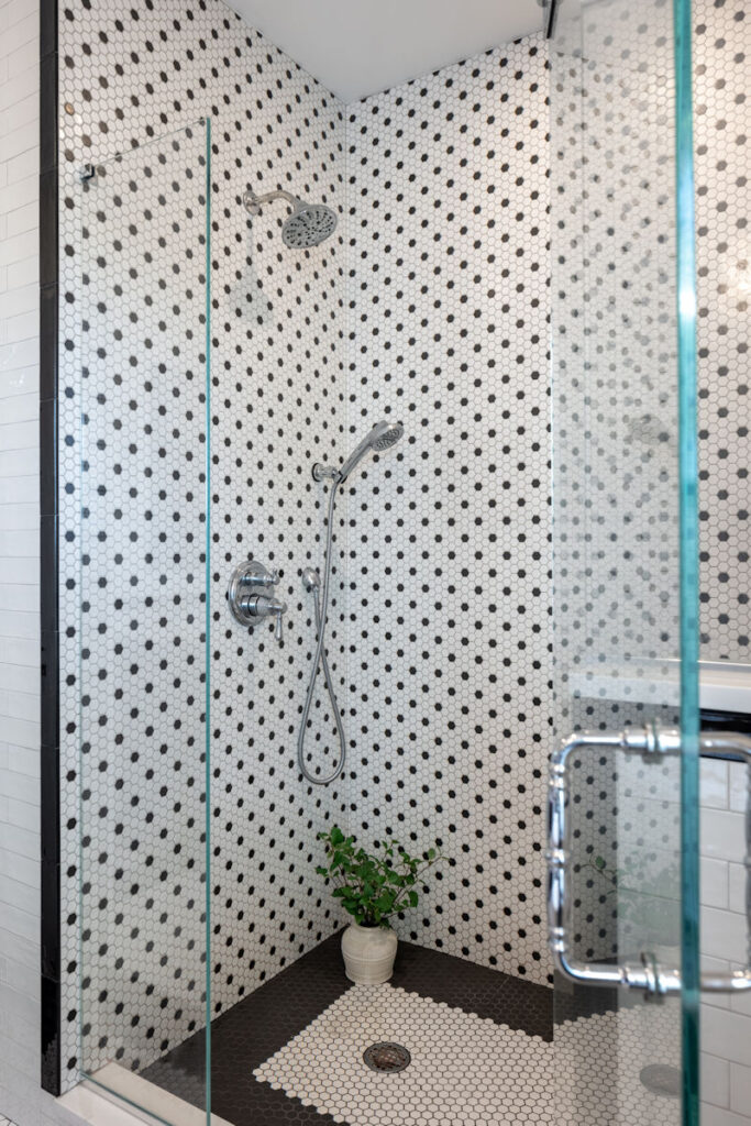 Bathroom remodel with custom black and white hexagon mosaic tile shower - McGuire + Co. Kitchen & Bath