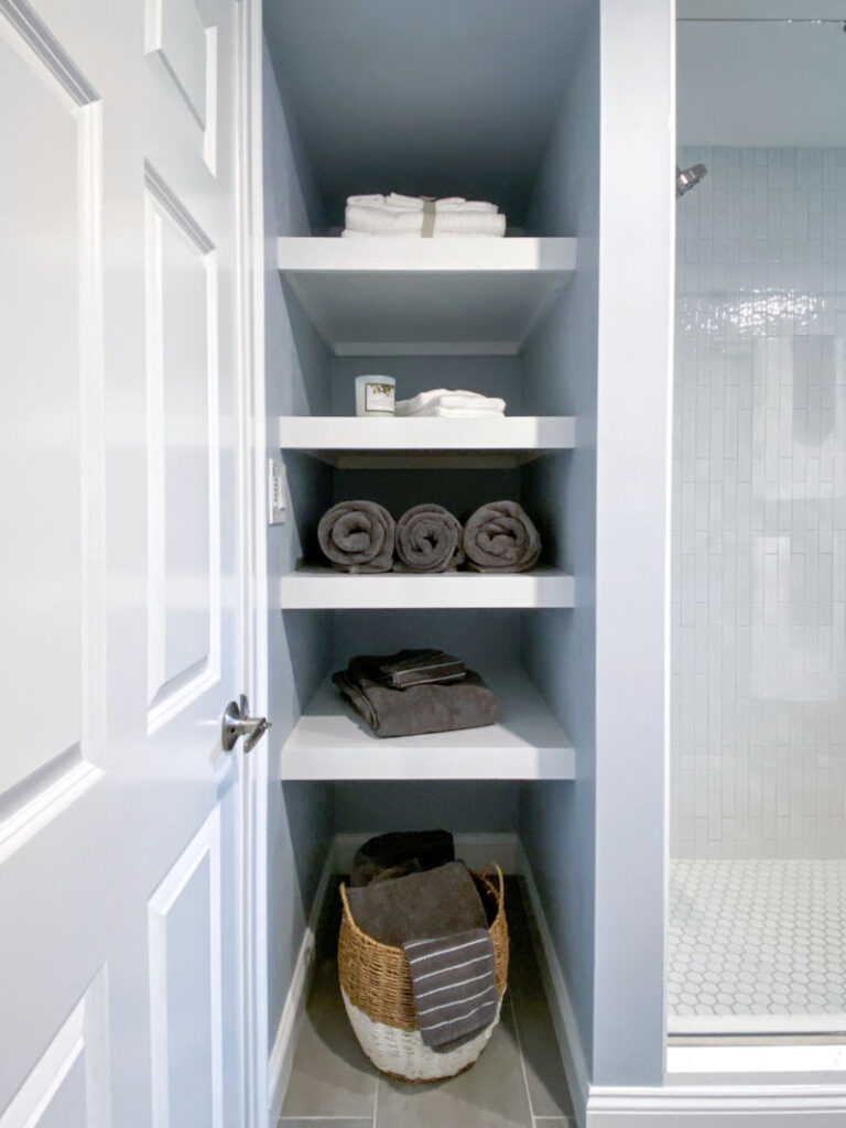 Basement bathroom remodel with tall open storage shelving