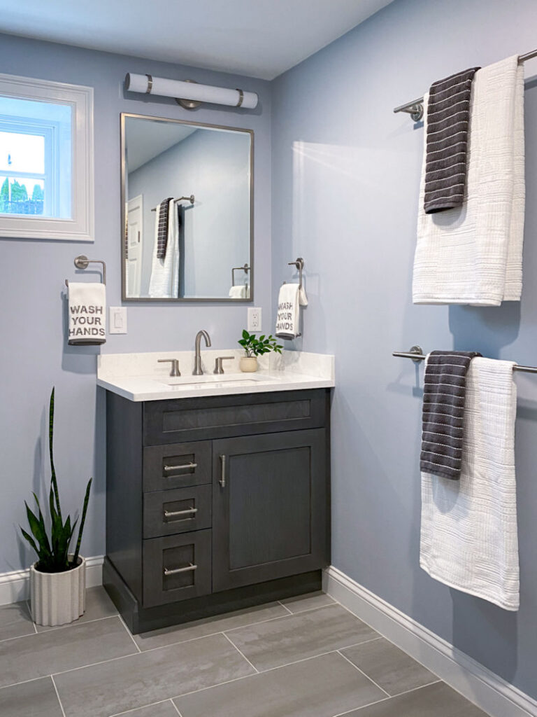 Charcoal gray stained vanity with white quartz countertop in Wakefield basement bathroom remodel