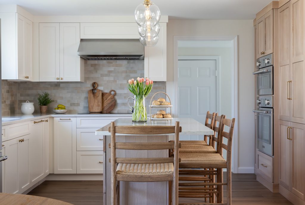 Woburn kitchen design and remodel with creamy white and white oak cabinets and soft neutral tile backsplash - McGuire + Co. Kitchen & Bath