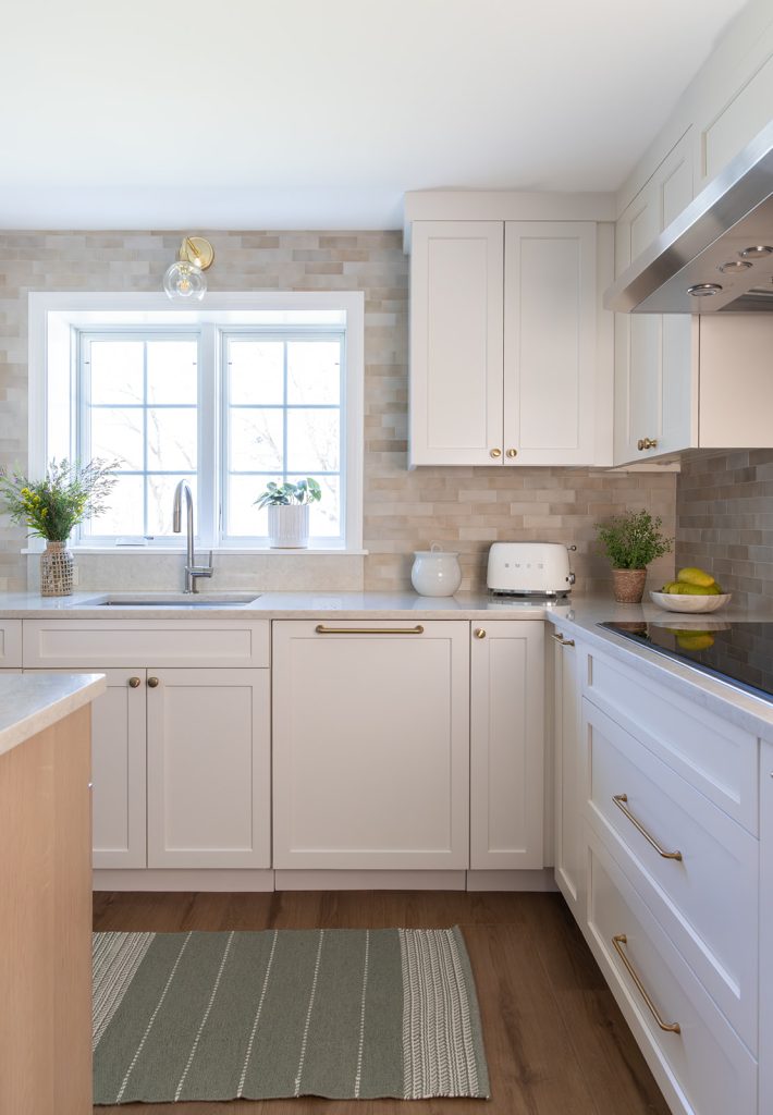 Woburn kitchen design and remodel with creamy white and white oak cabinets and soft neutral tile backsplash - McGuire + Co. Kitchen & Bath