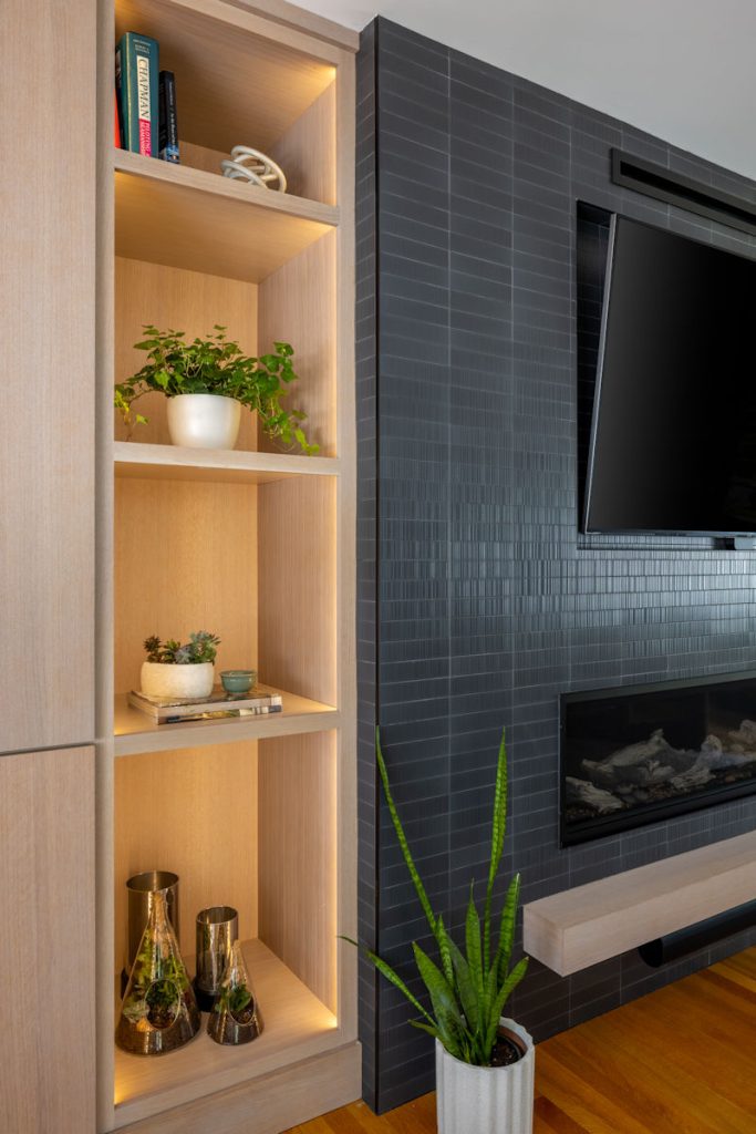 Lynnfield living room cabinetry with open shelving and black tile fireplace surround