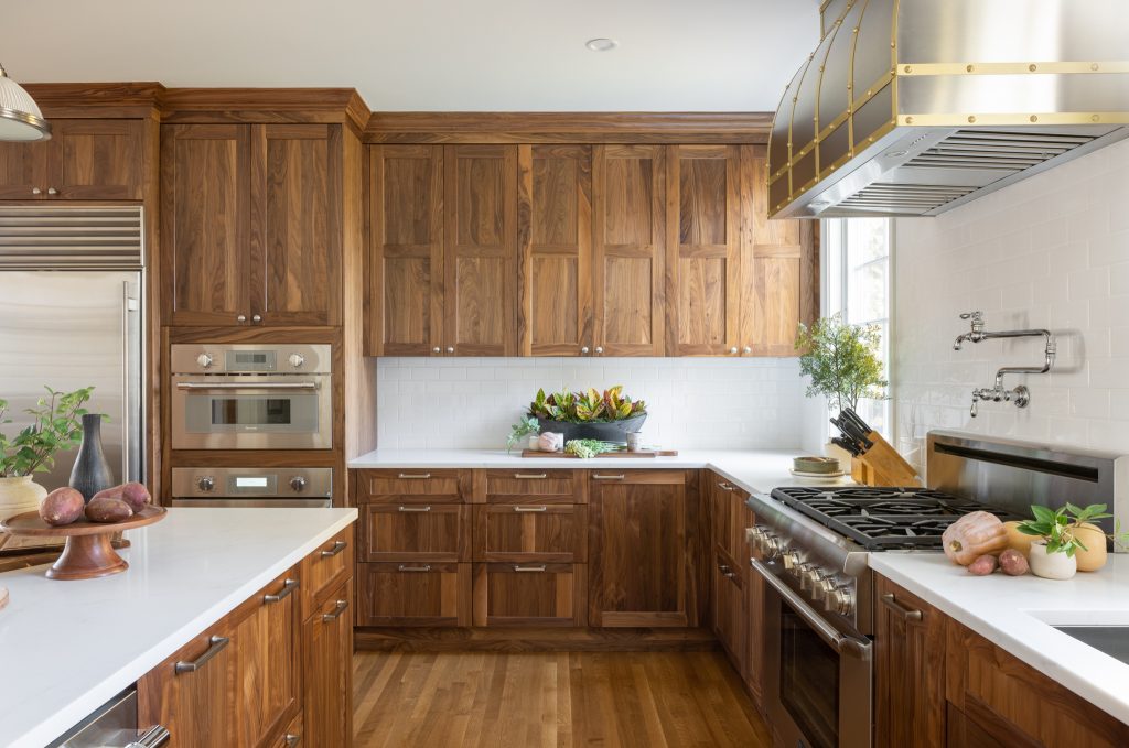 Kitchen design-build project with walnut cabinetry, quartz countertops and white subway tile backsplash.