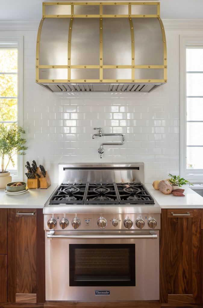 Kitchen design-build project with walnut cabinetry, stainless steel applilances, quartz countertops and white subway tile backsplash.